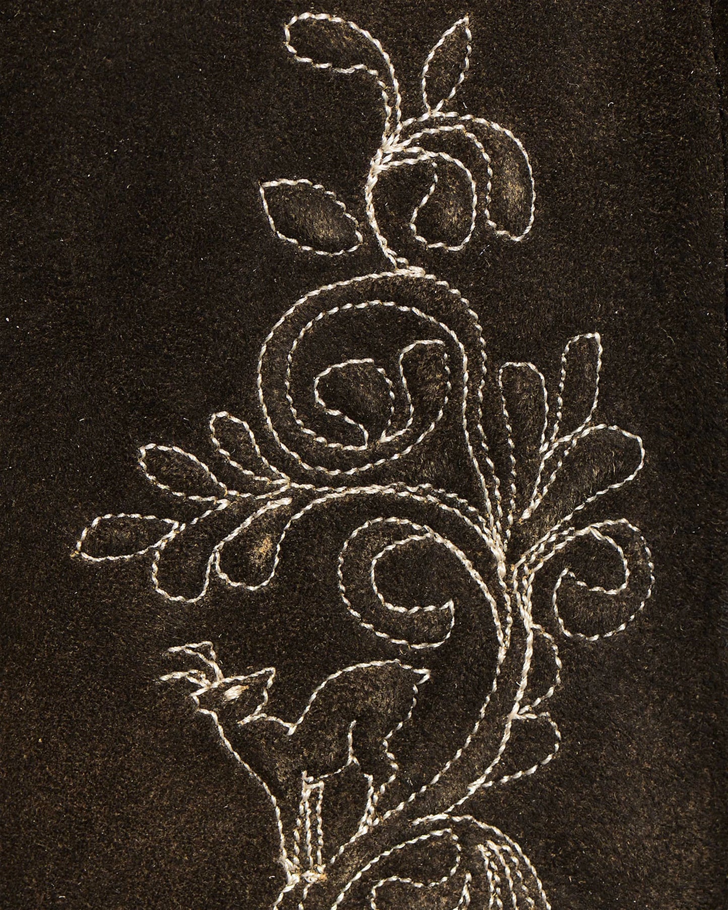 Decorative floral embroidery on a dark fabric background
