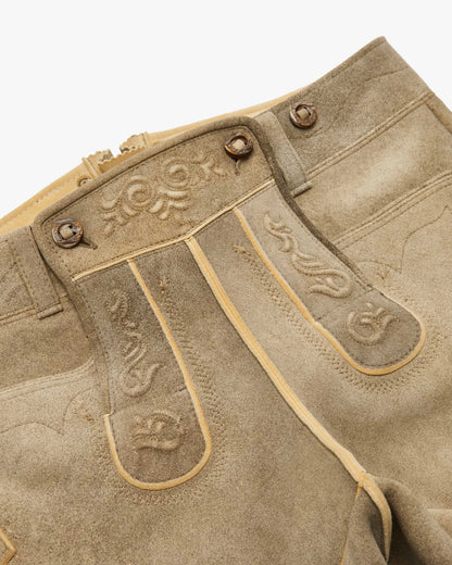 Close-up of a brown leather boot with decorative stitching on a white background