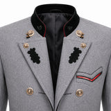 Close-up of a gray military-style double-breasted blazer with black peak lapels, gold buttons, black embroidered insignia, and red piping details on the pocket and collar.