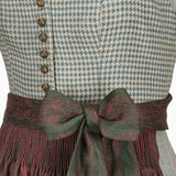 Close-up of a patterned garment with buttons and a bow tie on a white background