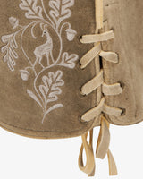 Close-up of a brown leather-bound book with white embroidered design on a white background