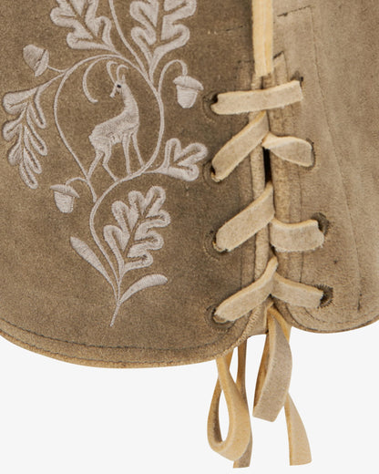 Close-up of a brown leather-bound book with white embroidered design on a white background
