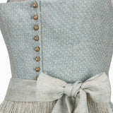 Close-up of a light blue dress with buttons and a bow detail.