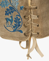 Beige leather boot with blue floral embroidery and laces on a white background