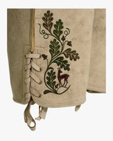 Embroidered fabric with a deer and leaf design on a beige background