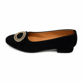 Black flat dirndl shoe with a decorative buckle on a white background