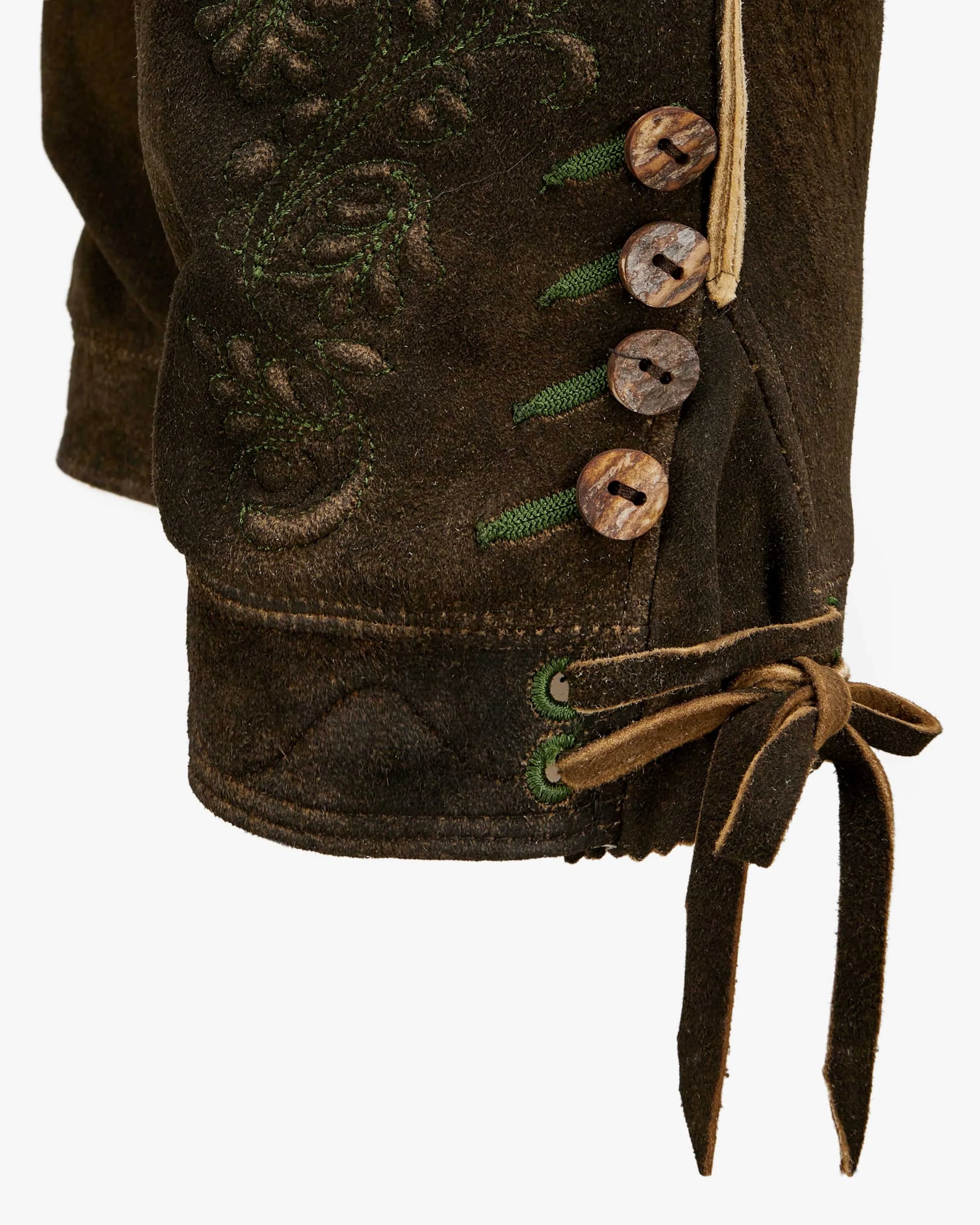 Close-up of a brown leather boot with decorative buttons and laces on a white background