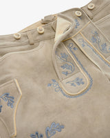 Close-up of a traditional outfit with embroidered details on a beige background