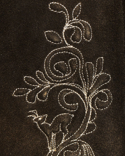 Decorative floral embroidery on a dark fabric background