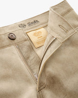 Close-up of beige pants with brand label and button details