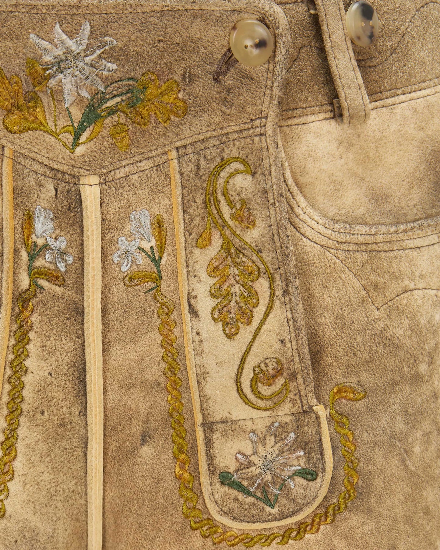 Close-up of embroidered fabric with floral patterns on a beige background