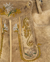 Close-up of embroidered fabric with floral patterns on a beige background