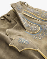 Close-up of a brown garment with blue embroidery on a white background