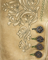 Close-up of a beige fabric with intricate embroidery and three wooden buttons.