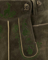 Brown leather jacket with green embroidered designs on a dark background