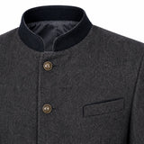 Close-up of a dark gray textured jacket with a black mandarin collar, bronze buttons, and a welt pocket on the chest.