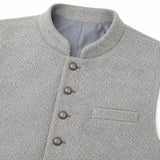 Close-up of a light gray textured waistcoat or vest with a mandarin collar, four front buttons, and a welt pocket on the chest.