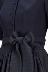 Navy blue dress with a bow detail on a white background