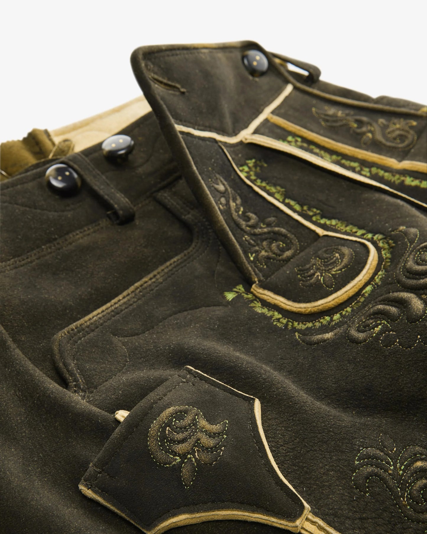Traditional black leather shorts with gold embroidery on a white background