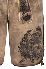 Close-up of a brown leather glove with intricate black embossed design on a white background