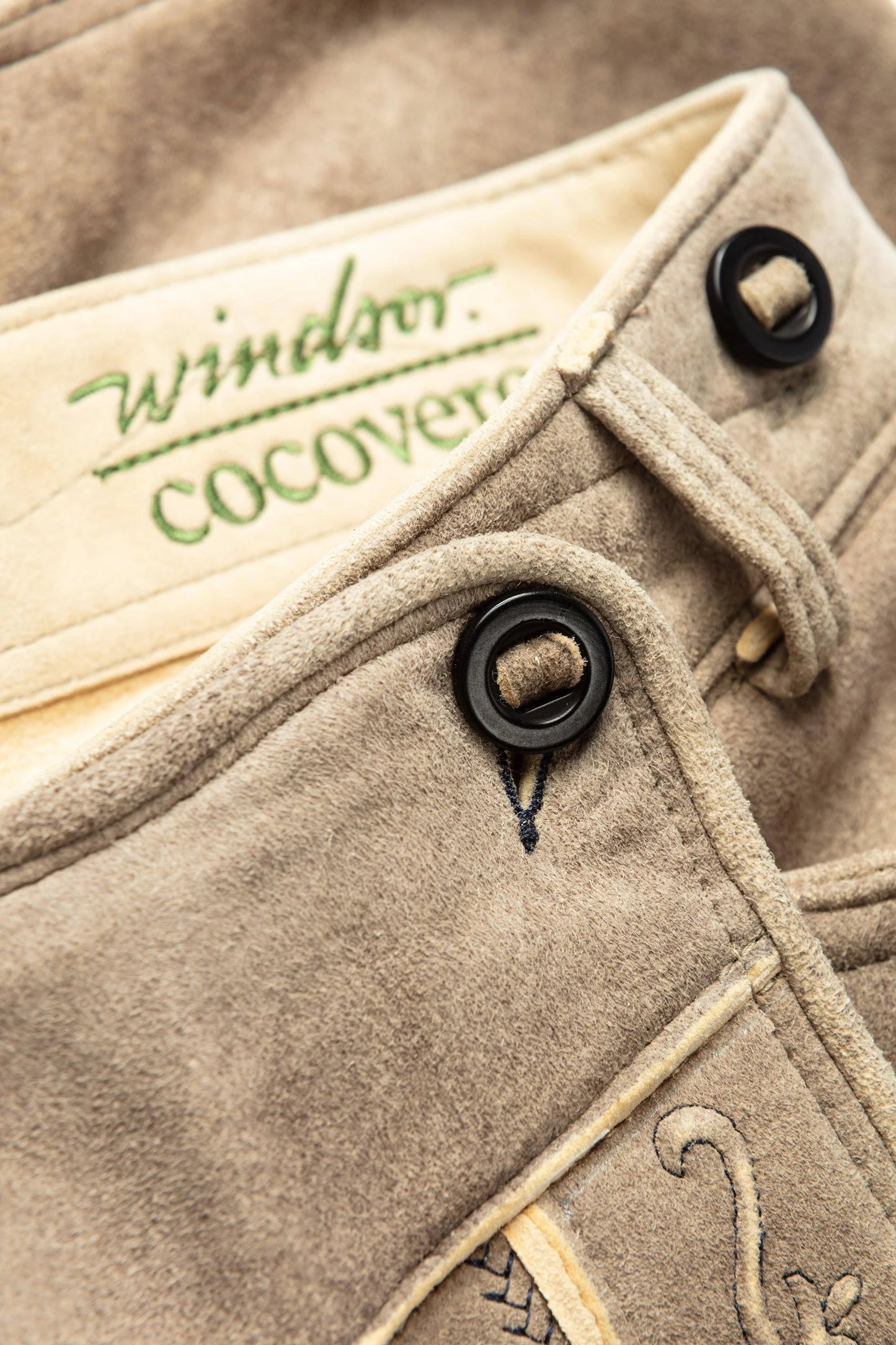 Close-up of a beige fabric with 'Windsor Cocover' branding and black buttons.