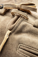 Close-up of a brown coat with a belt and button details