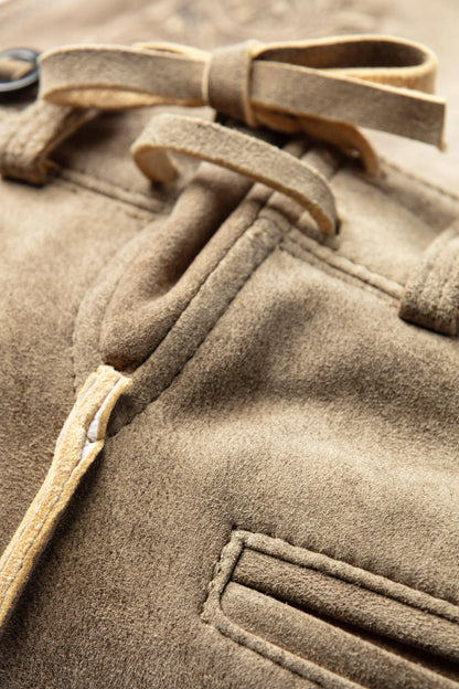 Close-up of a brown coat with a belt and button details
