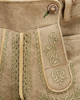 Close-up of a beige leather bag with intricate green embroidery