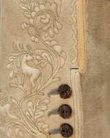 Close-up of a textured surface with intricate designs and buttons on a beige background