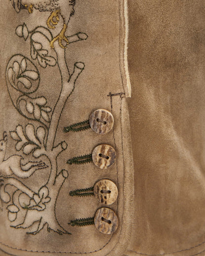 Close-up of a brown leather vest with embroidered design and buttons.