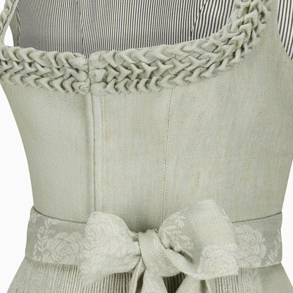 Light green apron with braided trim and a bow detail on a white background