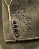 Close-up of a brown fabric with embroidered design and buttons.