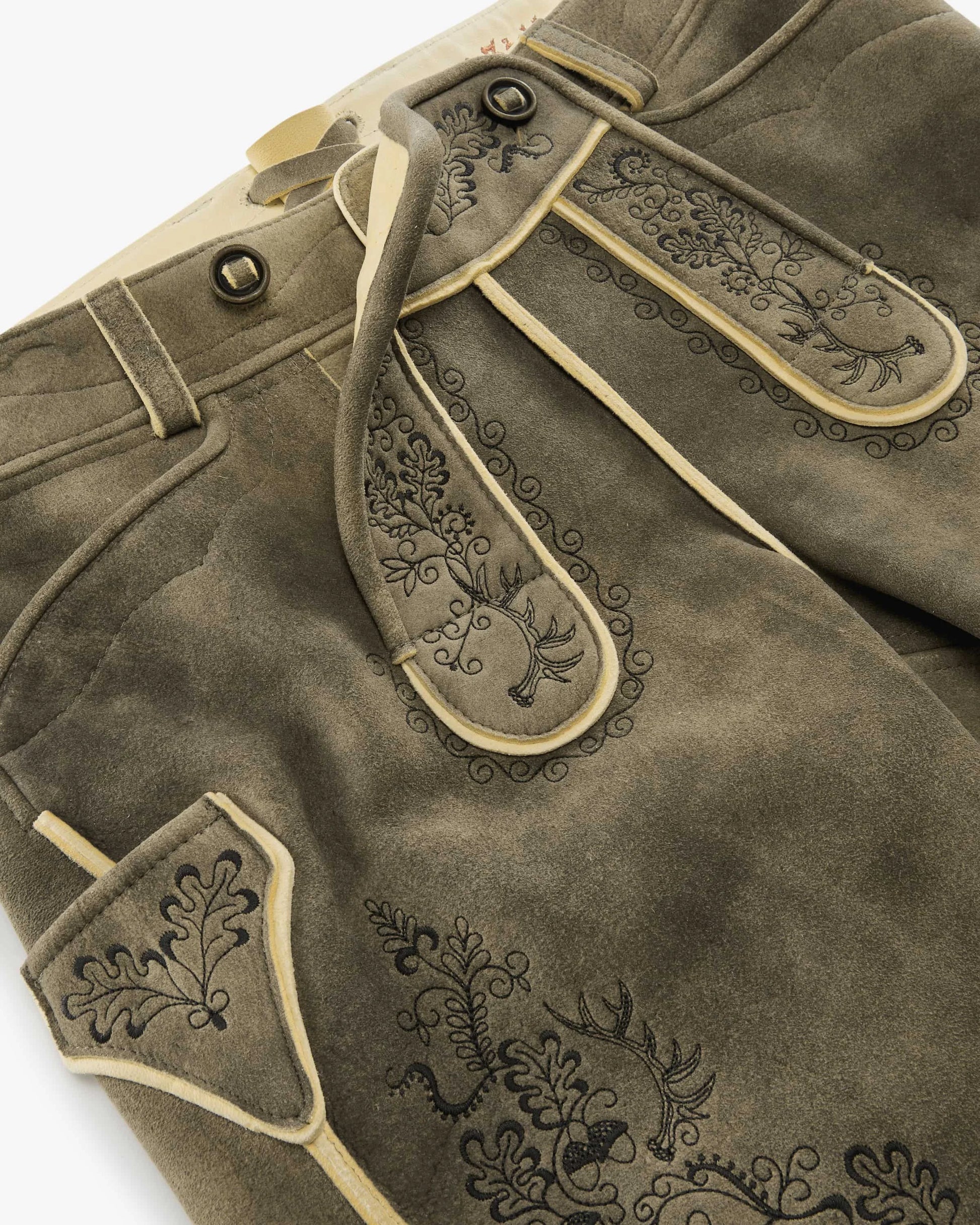 Brown leather pants with decorative stitching on a white background