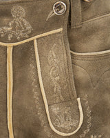 Close-up of brown leather pants with intricate white embroidery on a matching background