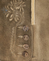 Close-up of a textured fabric with embroidered details and buttons.