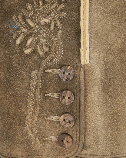 Close-up of a textured fabric with embroidered details and buttons.
