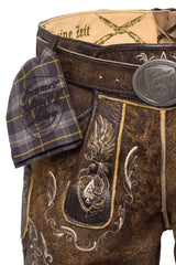 Close-up of a traditional brown leather outfit with intricate designs and a tartan pocket square.
