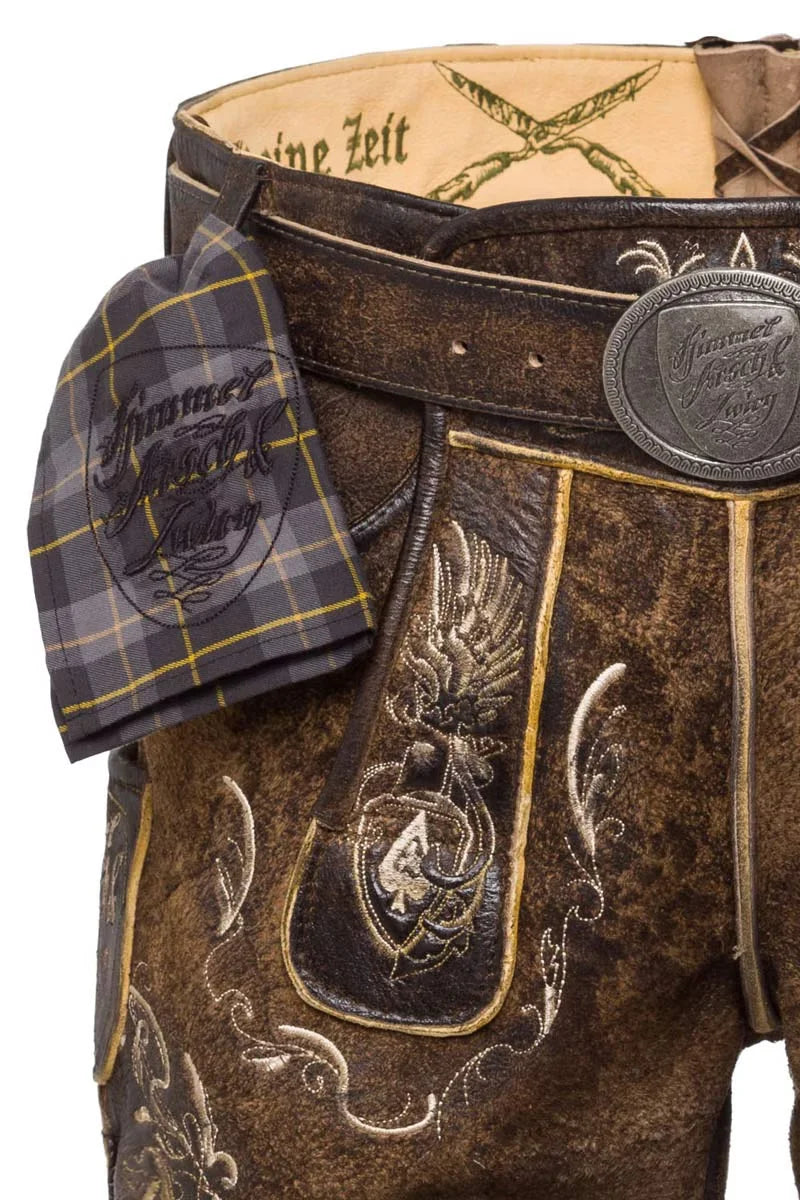 Close-up of a traditional brown leather outfit with intricate designs and a tartan pocket square.