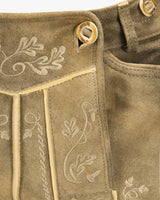 Close-up of brown fabric with embroidered floral patterns and button details.