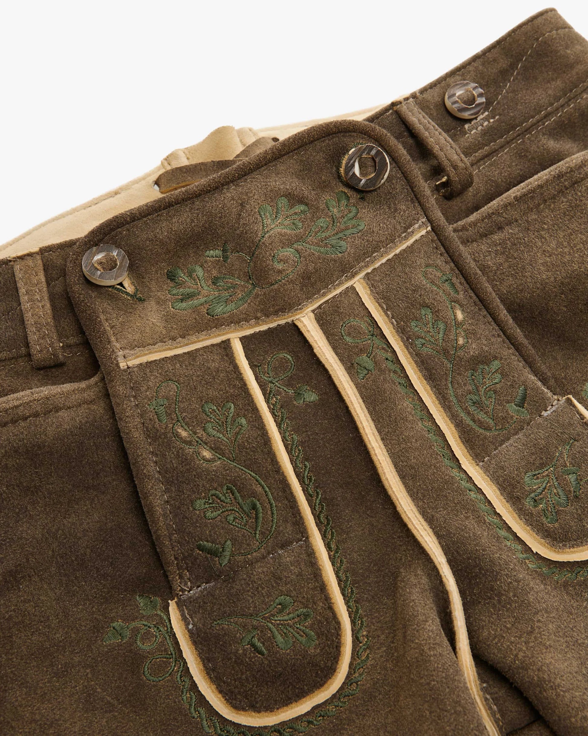 Brown pants with green embroidery on a white background