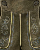 Close-up of brown leather pants with decorative stitching and patterns.