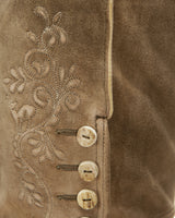 Close-up of a brown suede jacket with intricate embroidery and buttons.