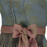 Close-up of a patterned garment with a pink bow and buttons.