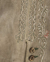 Close-up of embroidered fabric with intricate patterns on a beige background