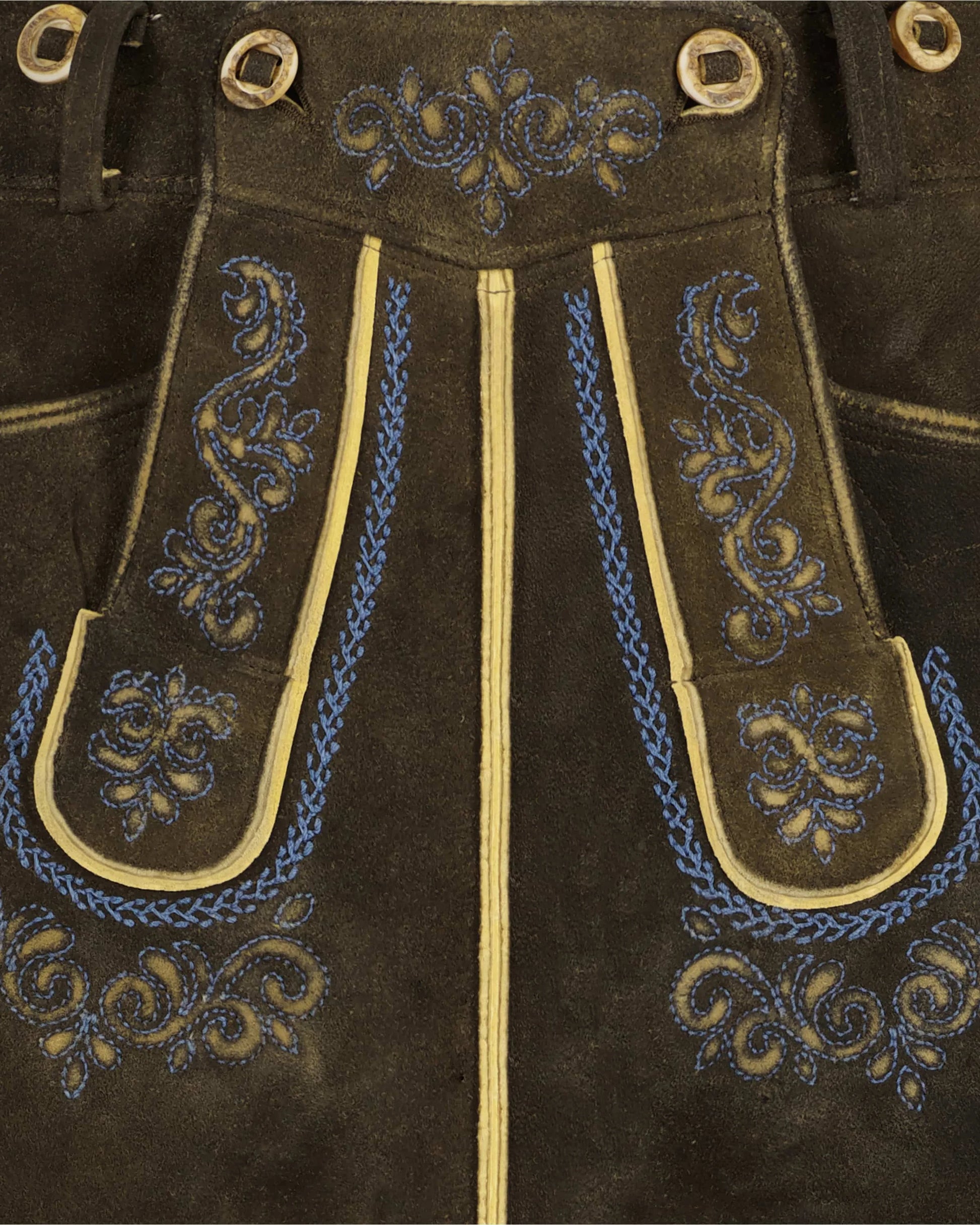 Brown leather pants with blue and gold embroidery and grommets.