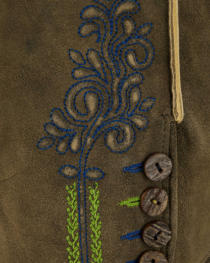 Close-up of a brown fabric with embroidered floral design and wooden buttons.