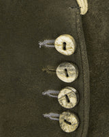 Close-up of a leather boot with metal buttons and laces on a dark background