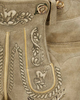Close-up of a brown leather boot with intricate embroidery and decorative elements.